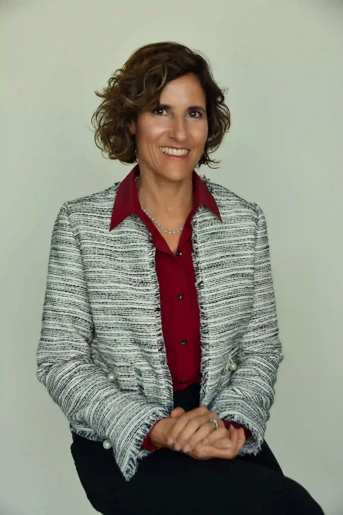 Carolann Mazza, wearing a gray jacket and red blouse